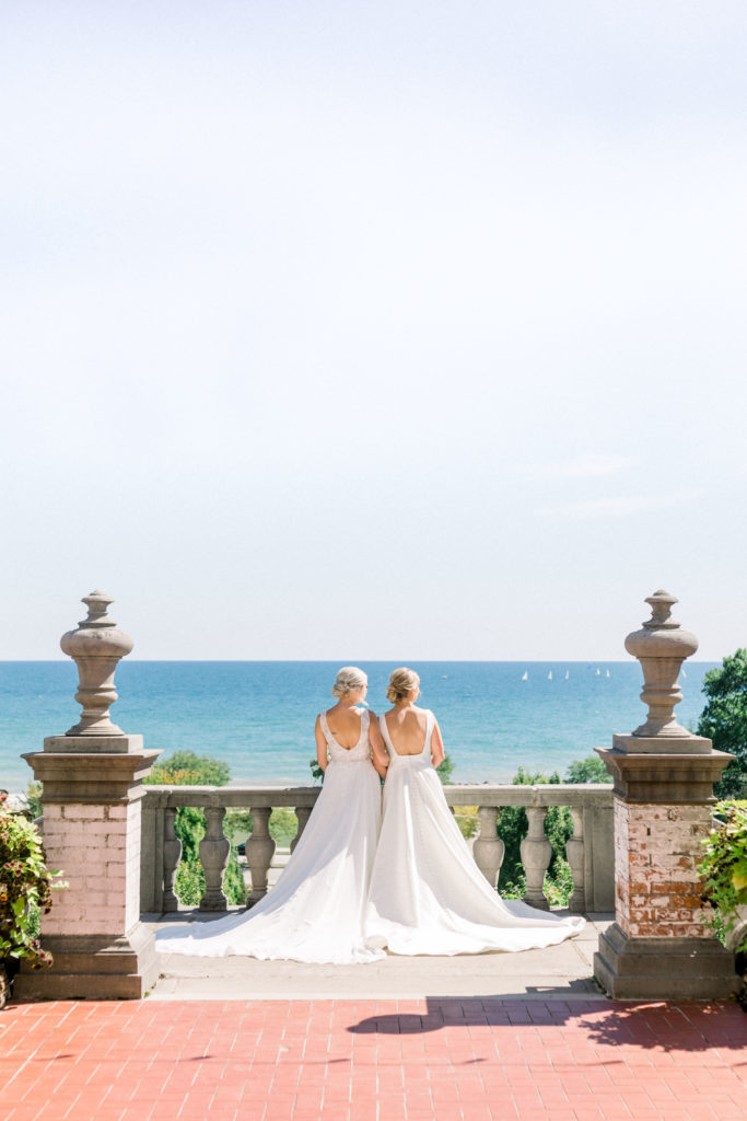 Two beautiful brides holding hands at Villa Terrace wedding, overlooking Lake Michigan