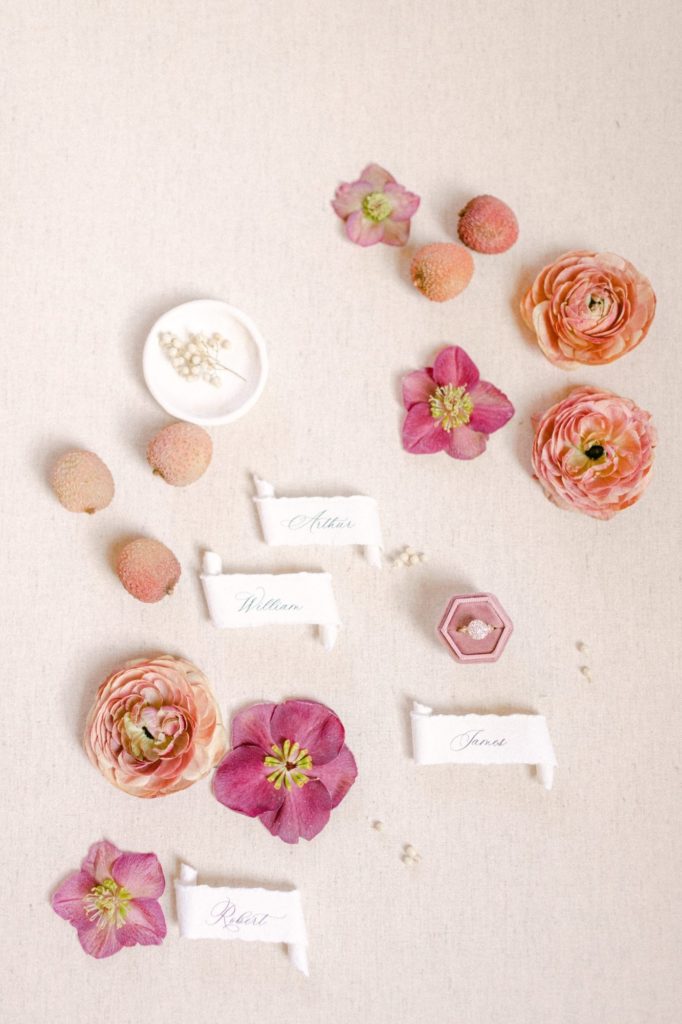 flatlay of name tags, hellebore and ranunculus