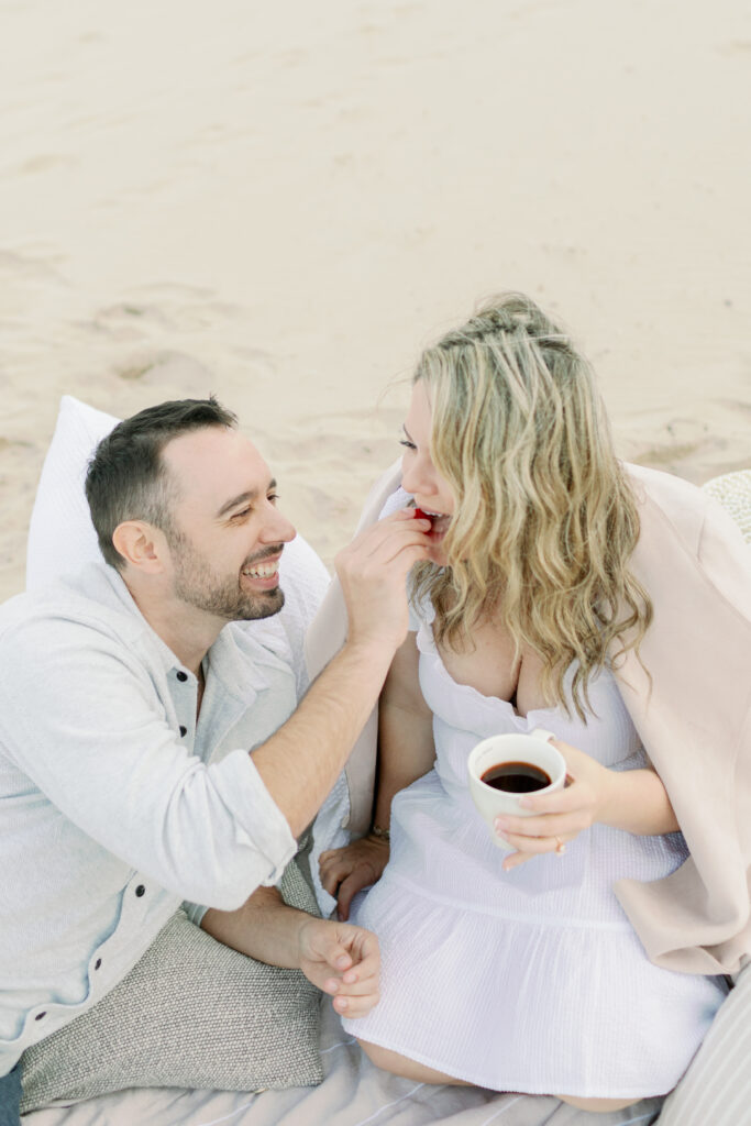 couple eating strawberries on beach