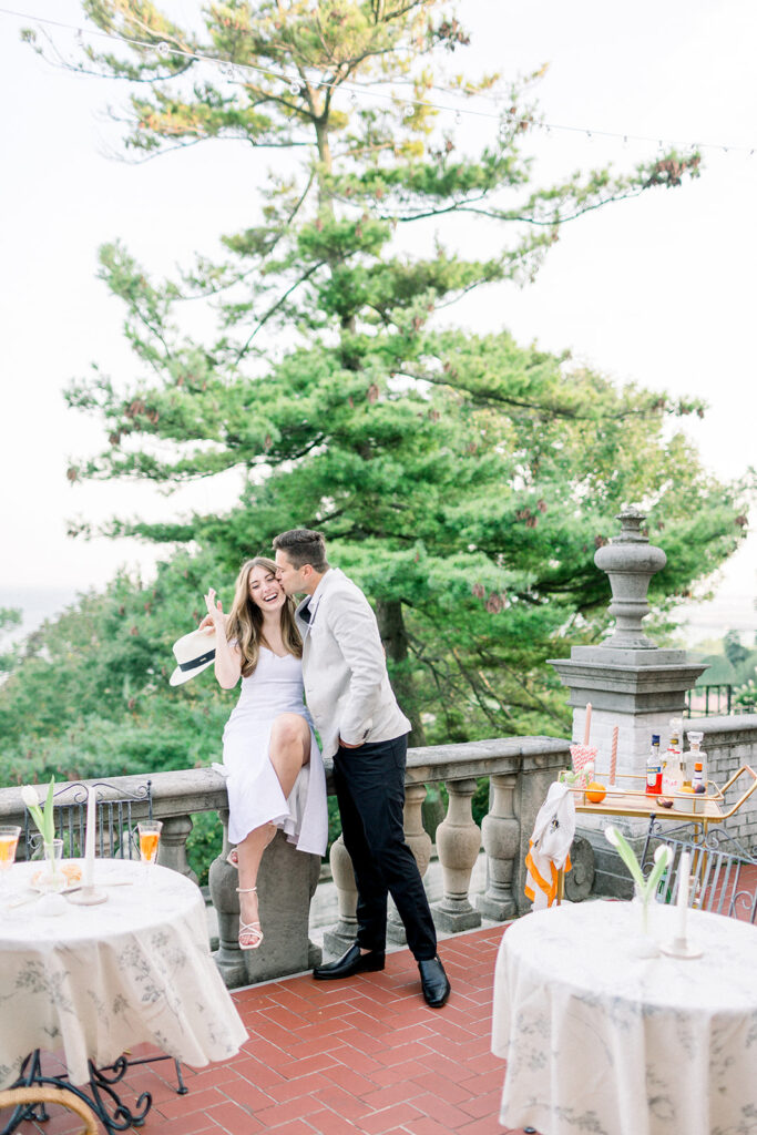 couple flirting on balcony in italy overlooking water