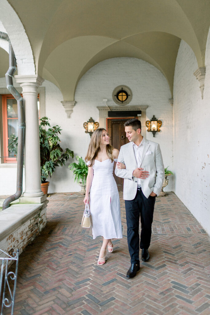 couple walking in italian courtyard hallway
